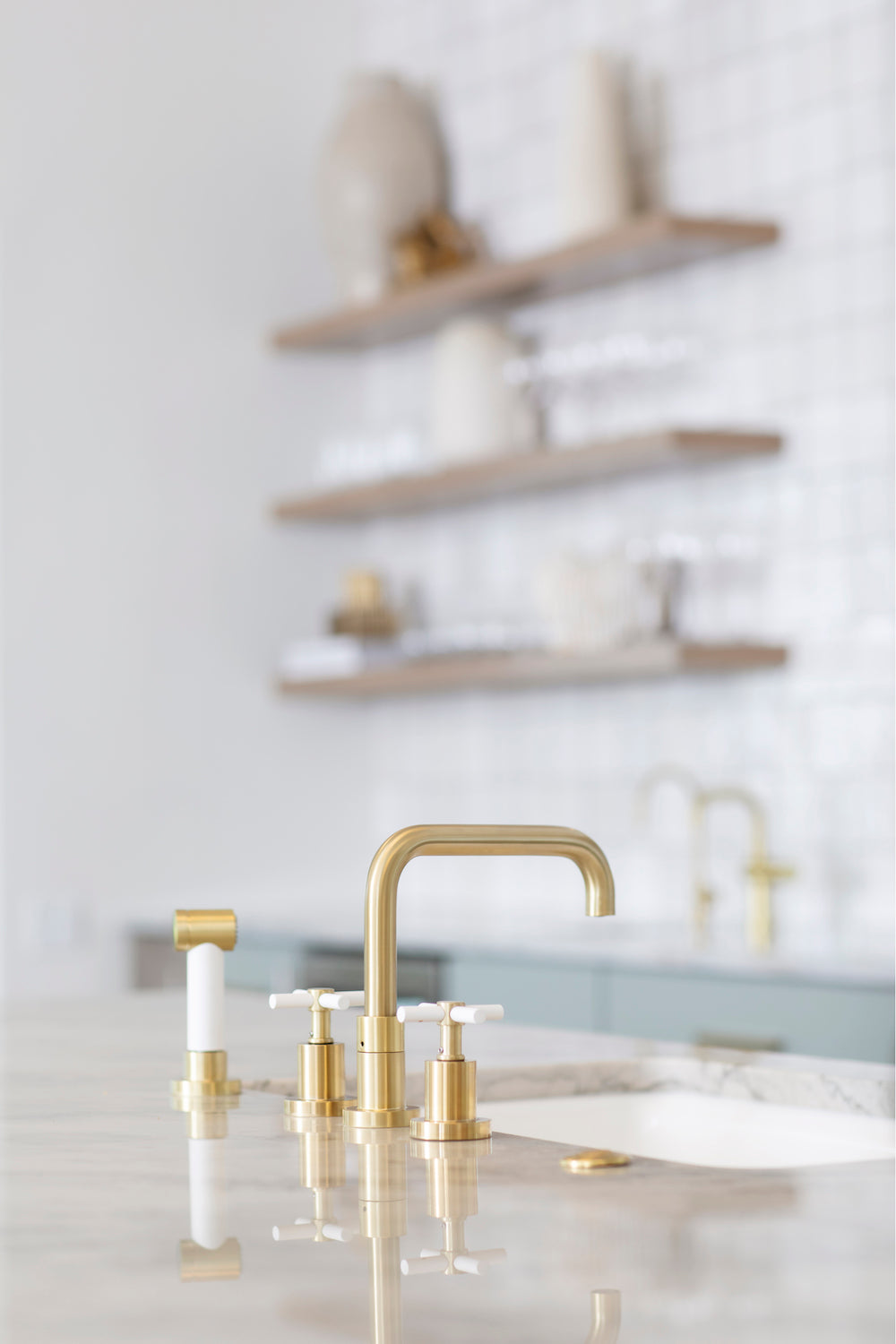 A coastal inspired kitchen with zellige tile, brass hardware, and serene blues by Lisa & Leroy.