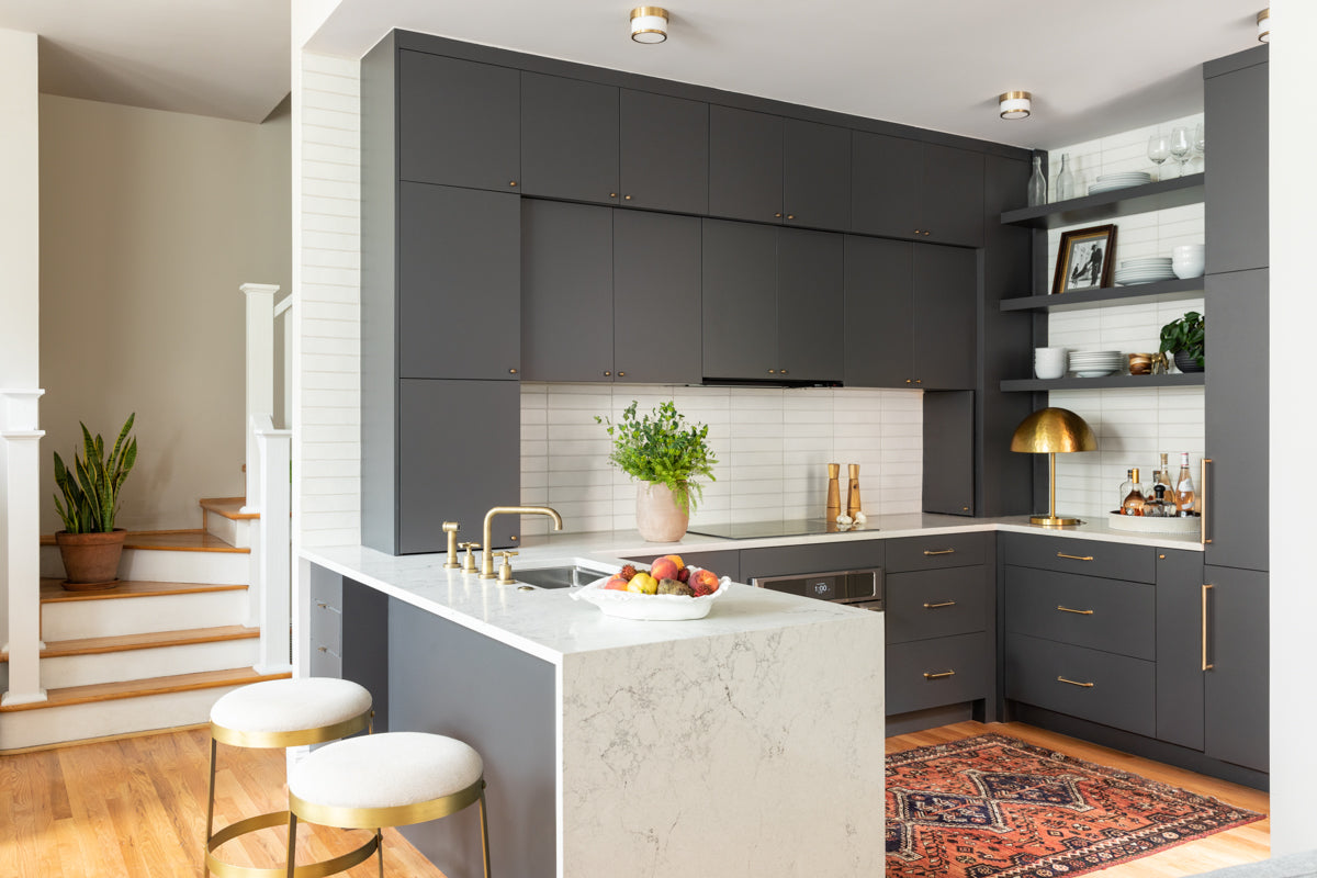 A modern kitchen by Lisa & Leroy, with waterfall marble island and horizontal tile.