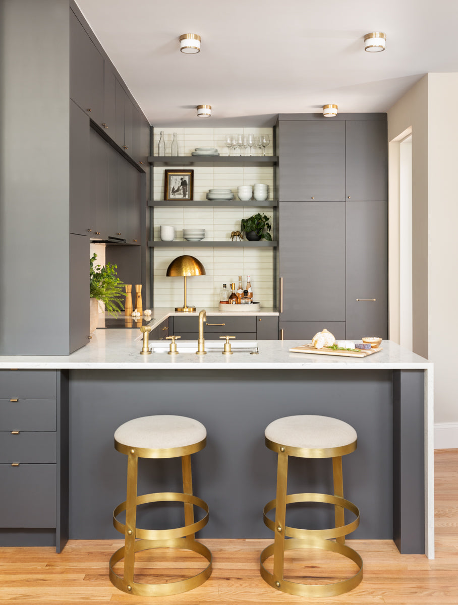 A modern kitchen by Lisa & Leroy with gray cabinetry and horizontal backsplash tiles.
