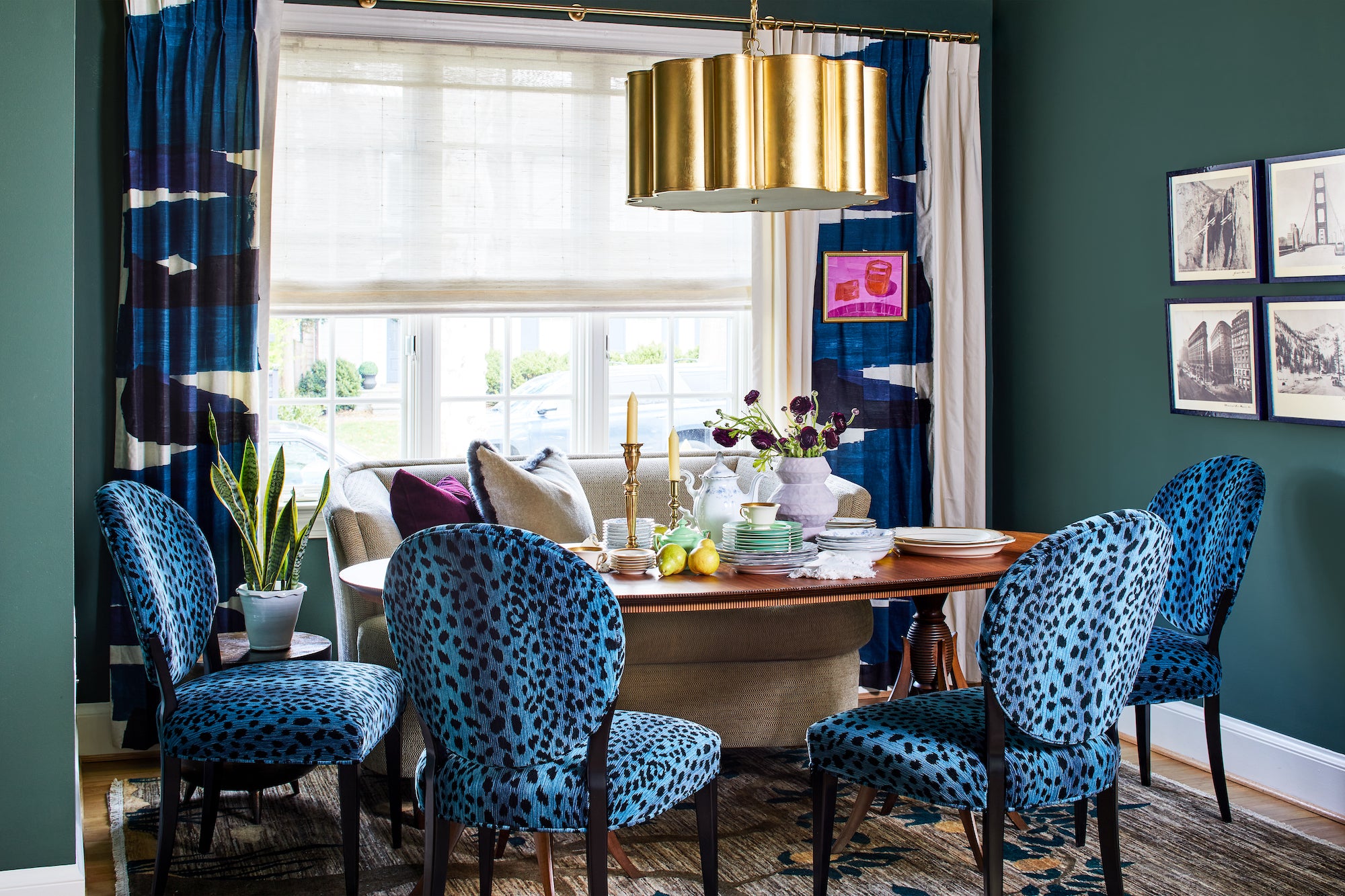 A jewel toned dining nook with an upholstered banquette and animal print chairs by Lisa & Leroy.