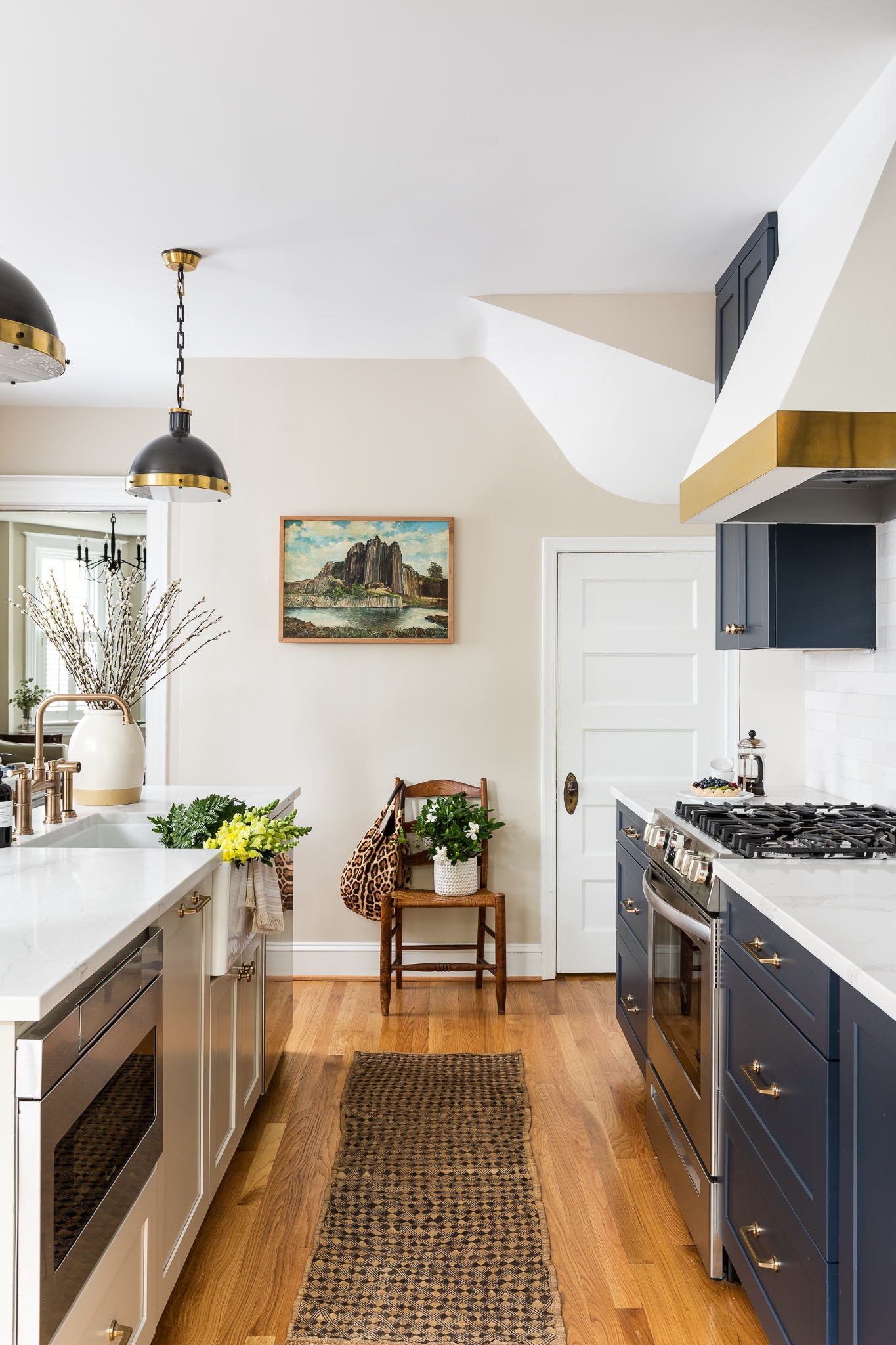 An elevated neutral kitchen with navy cabinets and ceramic tile, by Lisa & Leroy.