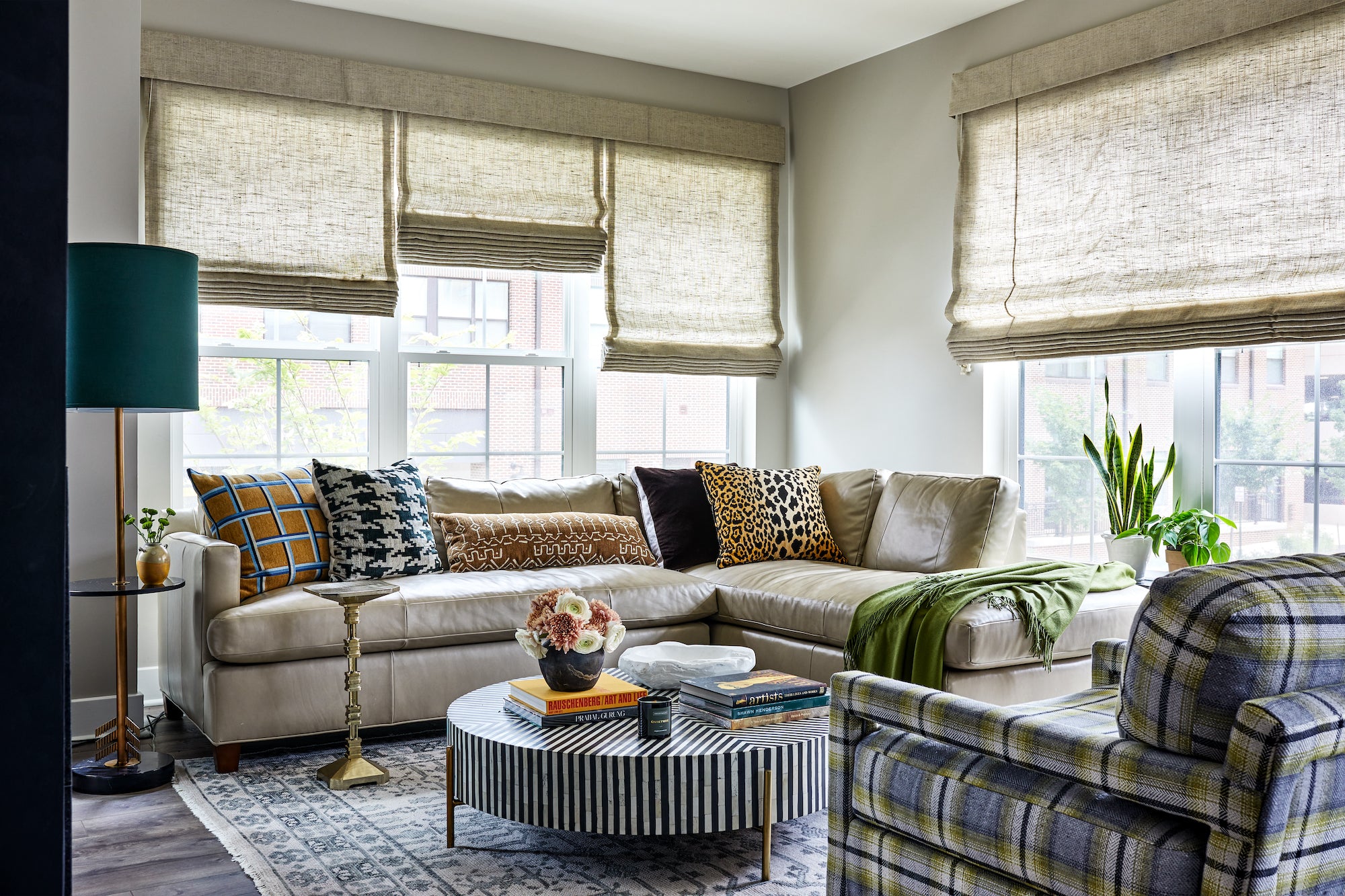 A layered living room featuring patterned textiles against neutral hues, by Lisa & Leroy.