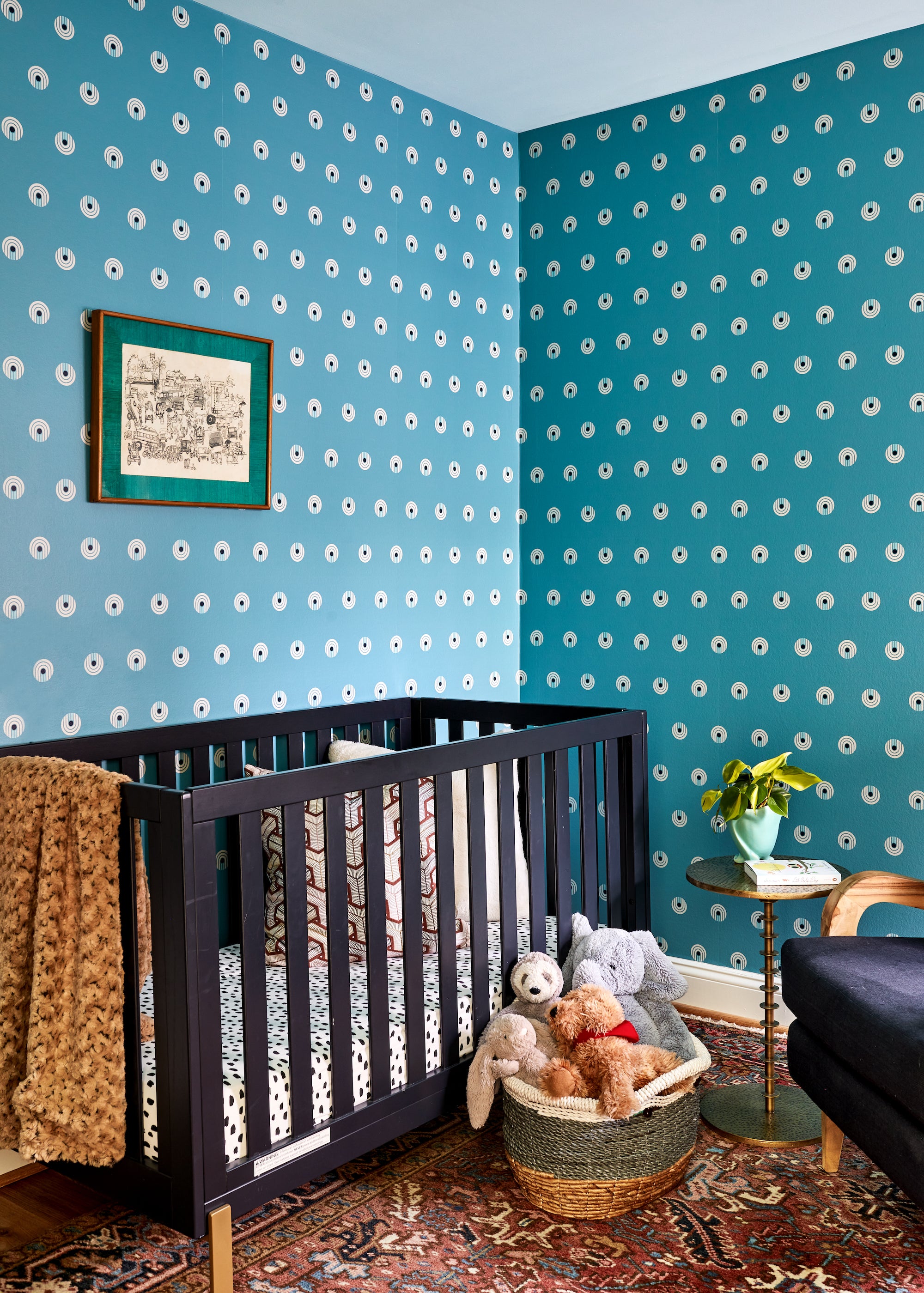 A playful nursery by Lisa & Leroy with wallpapered walls and a vintage rug.