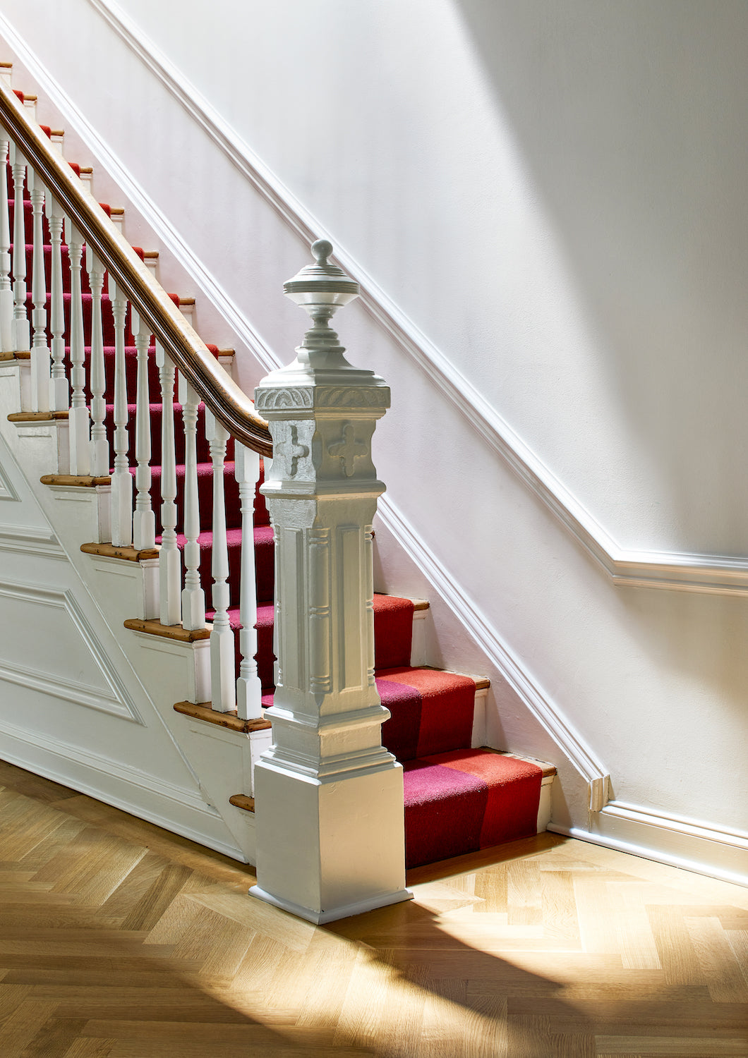 Stairs with antique moulding and a colorful, jewel-toned runner, by Lisa & Leroy.