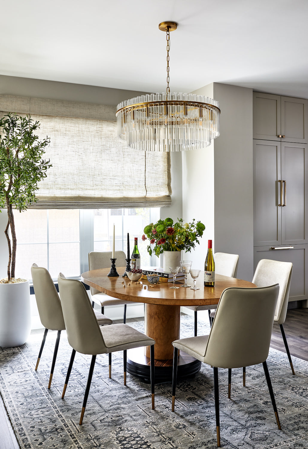 An elevated, neutral dining area with statement lighting by Lisa & Leroy.