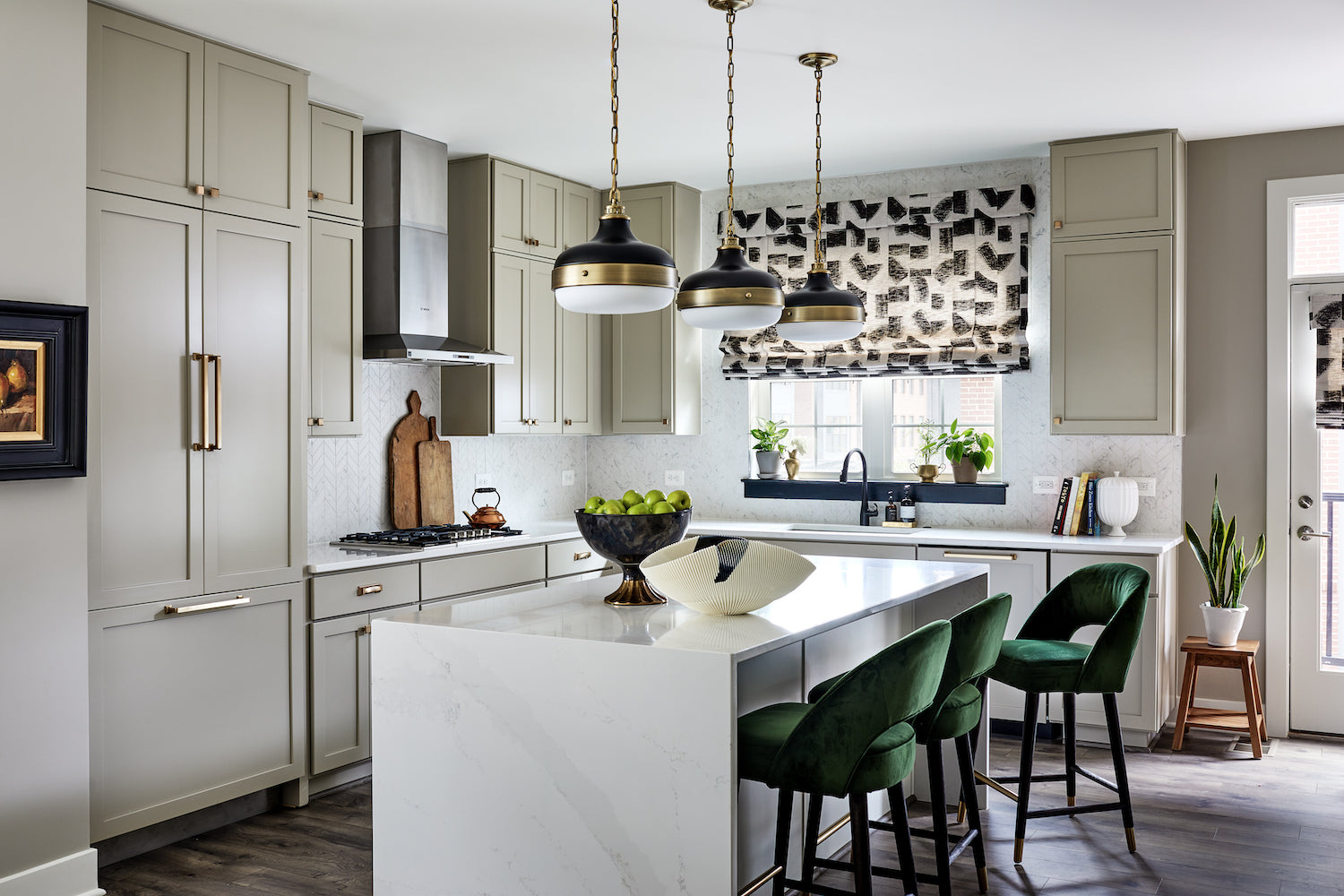 An elevated, neutral kitchen with accents of deep green by Lisa & Leroy.